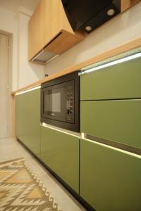 a microwave oven on a wall in a kitchen at Green Studio in Tîrgu Neamţ