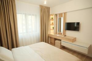 a hotel room with a bed and a television at Green Studio in Târgu Neamț