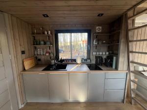 uma cozinha numa pequena casa com uma janela em Hytte Narie 1 em Morąg