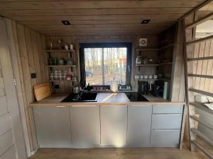 a kitchen in a tiny house with a window at Hytte Narie 1 in Morąg