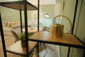a brass tea kettle on a shelf in a living room at Green Studio in Tîrgu Neamţ