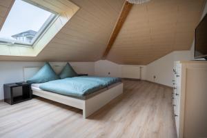 a bedroom with a bed with blue sheets and a window at Ferienwohnung Krist in Osburg