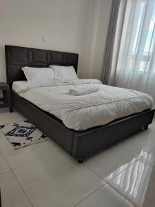 a bed with a black frame in a bedroom at Eden Homes - NEAR JKIA & SGR in Nairobi