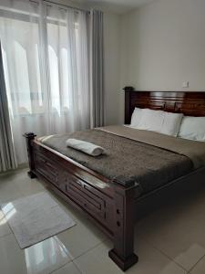- un lit avec un cadre en bois dans une chambre dans l'établissement Eden Homes - NEAR JKIA & SGR, à Nairobi