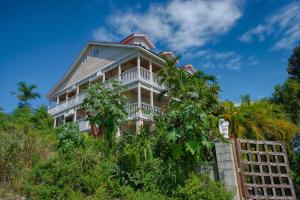 uma casa grande no topo de uma colina com árvores em A Stone's Throw Away em Nassau