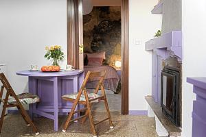 Cette chambre comprend une table et des chaises violettes ainsi qu'un lit. dans l'établissement Lago Iseo View, à Zone