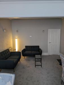 a living room with two couches and a table at Rossdene House in Blackpool