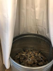 a metal bucket filled with coins next to a curtain at Amazing Loft on Horse Ranch in Pilot Hill