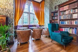 biblioteca con sillas, mesas y estanterías en 9 Bedrooms Grand Manor House Near Bath, Sleeps 26 en Seend