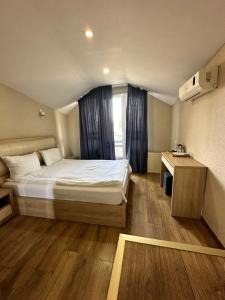 a small bedroom with a bed and a window at Hotel Lile in Tbilisi City