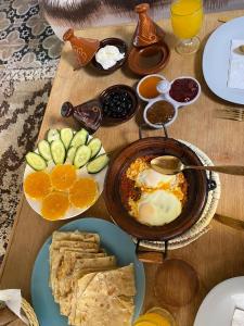 a wooden table topped with plates of breakfast food at Casa Mona in Merzouga