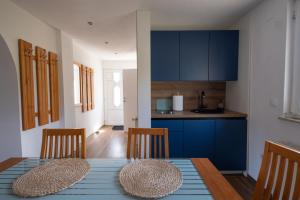 a kitchen with blue cabinets and a table and chairs at Studio Apartman Mak in Bihać