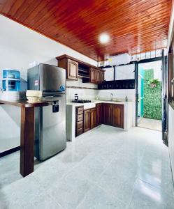 a large kitchen with wooden cabinets and stainless steel appliances at De Greiff House in San José del Guaviare