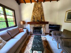 a living room with a couch and a fireplace at Casa Família, piscina, hidro aquecida, cercada in Petrópolis