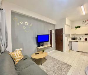 een woonkamer met een bank en een tv aan de muur bij סוויטה חדשה על חוף בוגרשוב המבוקש in Tel Aviv