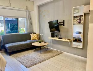 a living room with a couch and a tv and a table at סוויטה בוגרשוב על הים in Tel Aviv