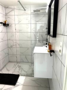 a white bathroom with a sink and a shower at Logement Woluwé in Brussels