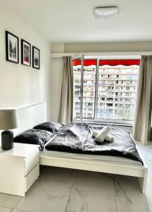 ein Schlafzimmer mit einem großen Bett und einem Fenster in der Unterkunft Logement Woluwé in Brüssel