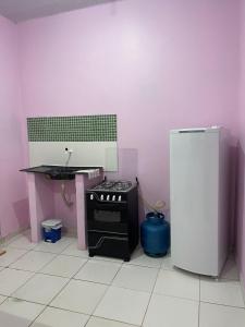 a kitchen with a stove and a sink and a refrigerator at Kit net CN in Ananindeua
