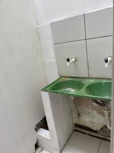 a bathroom with a green sink in a room at Kit net CN in Ananindeua