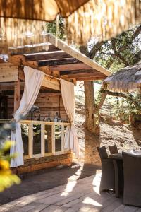 ein Holzgebäude mit einem Tisch und Stühlen davor in der Unterkunft Boskenvid Hotel Boutique, Skypool in Valle de Guadalupe