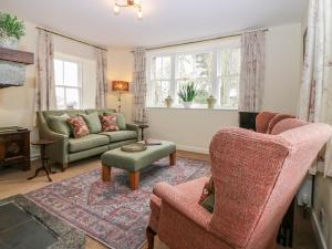 een woonkamer met 2 stoelen en een bank bij Steading Cottage - Craigievar Castle in Alford