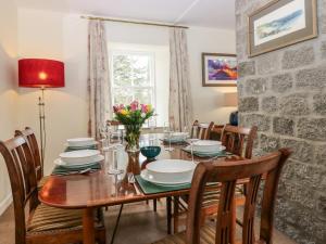 een eetkamer met een houten tafel en stoelen bij Steading Cottage - Craigievar Castle in Alford