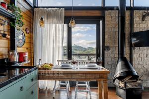 uma cozinha com uma mesa e uma grande janela em Mountain Chalet Jacuzzi com Vista em Rancho Queimado