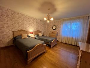 1 dormitorio con 2 camas y lámpara de araña en VILLA OSTRERA, en Suances