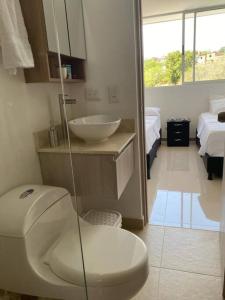 a bathroom with a white toilet and a sink at Hermoso y acogedor apartamento! in Santa Fe de Antioquia