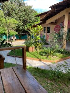 a wooden bench in front of a house at Pousada Recanto dos Sonhos in Alto Paraíso de Goiás