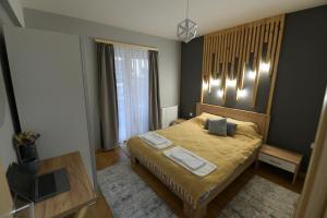 斯科普里Skopje CityNest Apartment的一间卧室配有一张床和一台笔记本电脑
