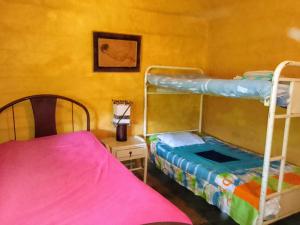 Hostal Colina de San Antonio في Jamundí: غرفة نوم بسريرين بطابقين وسرير