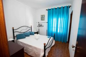 a bedroom with a bed with blue pillows at Casa 'Saudade' in Moura