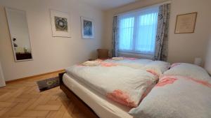 a bed in a room with a window at Renovierte 4.5Zimmerwohnung 90m2 in Wil