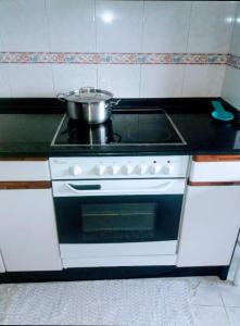 a kitchen with a stove with a pot on it at PISO DEL PARQUE 2 in Santiago de Compostela