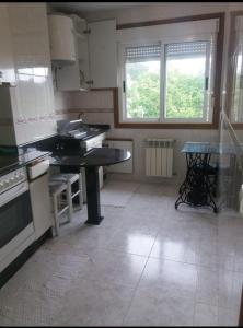 a kitchen with a counter and a table in it at PISO DEL PARQUE 2 in Santiago de Compostela