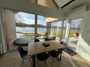 a dining room with a table and chairs and a large window at Panacea in Lazdijai
