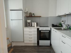a kitchen with white cabinets and a black and white appliance at City Apartment in Tampere