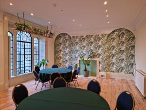 una sala riunioni con tavoli e sedie di fronte a un muro di 9 Bedrooms Grand Manor House Near Bath, Sleeps 26 a Seend