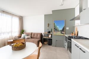 a kitchen and living room with a table and a couch at Apartamento no coração de Bento Gonçalves in Bento Gonçalves