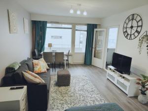 City Apartment في تامبير: غرفة معيشة مع أريكة وساعة على الحائط