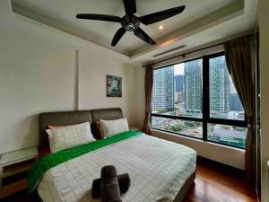 a bedroom with a bed with a ceiling fan and a window at Casa Residency Service Apartment By Moonlight in Kuala Lumpur +26 photos
