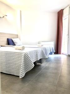 a bedroom with two beds and a tile floor at Casa de Feliz in Calpe