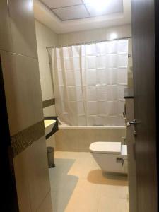 een badkamer met een toilet, een wastafel en een bad bij Luxury Studio/Apartment in JVC in Dubai