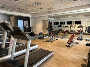 een fitnessruimte met veel fitnessapparatuur en spiegels bij Luxury Studio/Apartment in JVC in Dubai