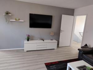 a living room with a white cabinet and a tv on the wall at LaPurka ll Home in Nordhorn