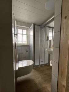 ein Bad mit einer Badewanne, einer Dusche und einem Waschbecken in der Unterkunft Urig, gemütliches Fachwerkhaus in Korbach