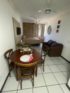 uma sala de estar com uma mesa e cadeiras e um sofá em EDIFÍCIO METROPOLE ONDINA em Salvador