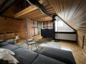 a living room with a couch and a tv at Urig, gemütliches Fachwerkhaus in Korbach